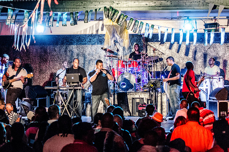 Carimi performing live on stage before a large crowd at an outdoor concert