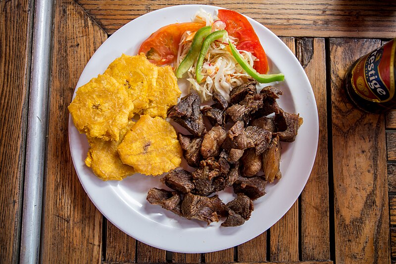 A plate of Haitian griot — golden fried pork pieces served as a traditional celebratory dish