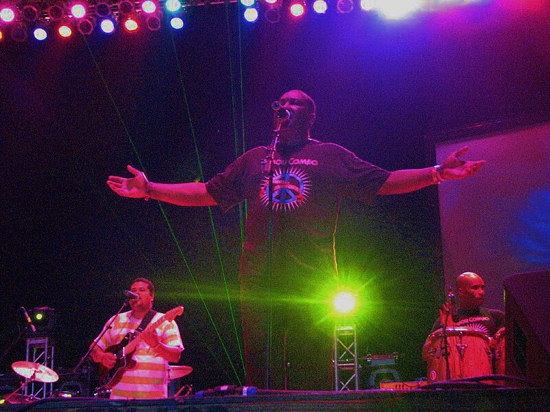 Tabou Combo performing live on stage in Jacmel, Haiti, with colorful stage lights